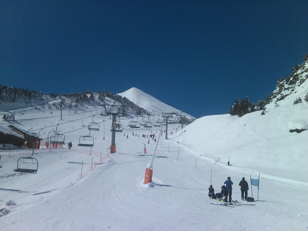 Skiers waiting by a chairlift on a snowy slope in the Arinsal sector of Pal Arinsal, Andorra