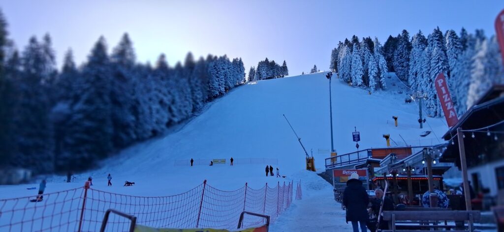 Snowy piste lined with pine trees at the base of the Borovets ski area, Bulgaria