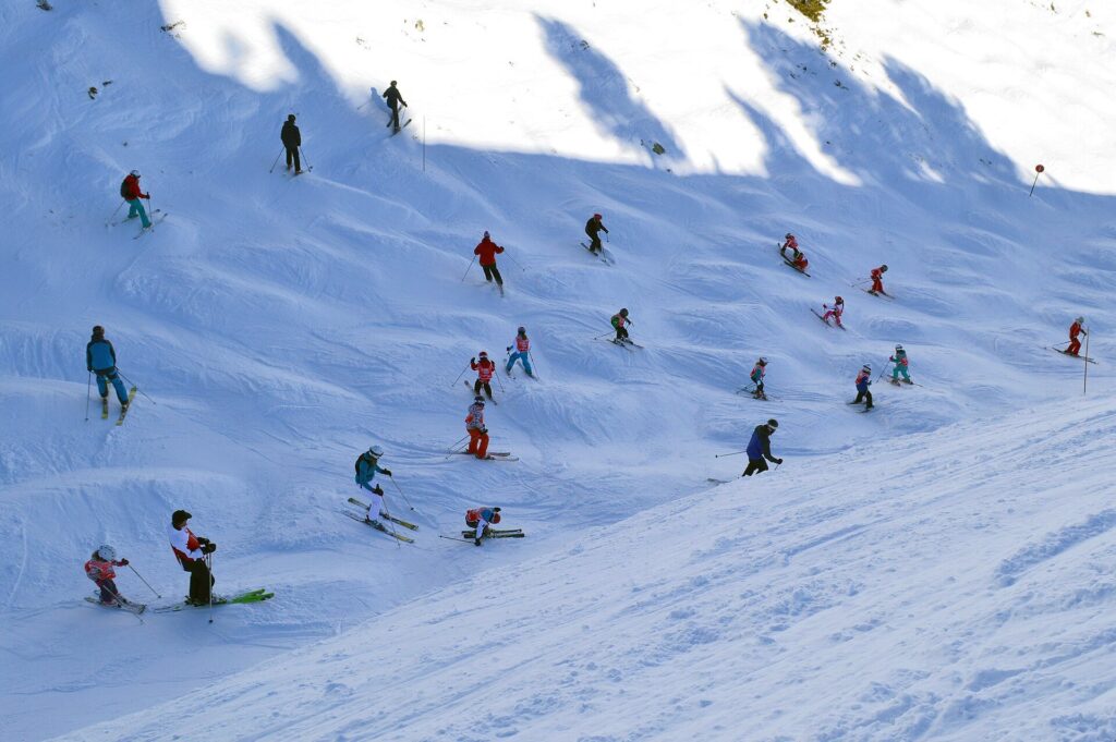 Ski school group following an instructor down a snowy slope