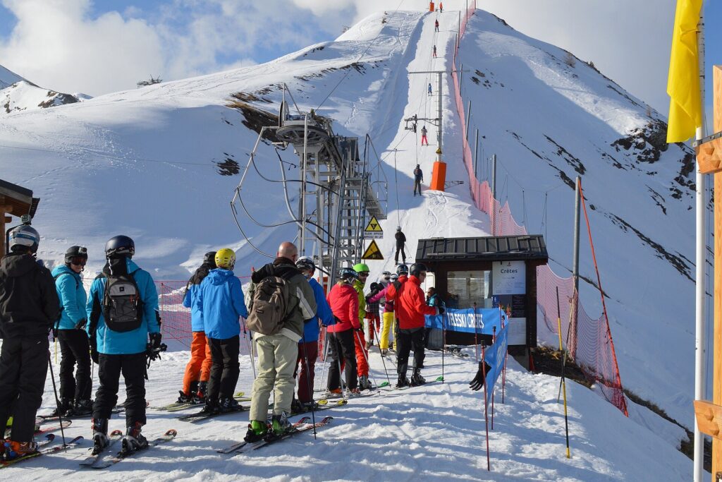 Skiers queueing for a T-bar drag lift on a sunny day